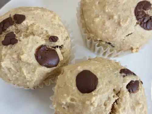 Fluffy healthy oat flour chocolate chip muffins served on a clean white plate
