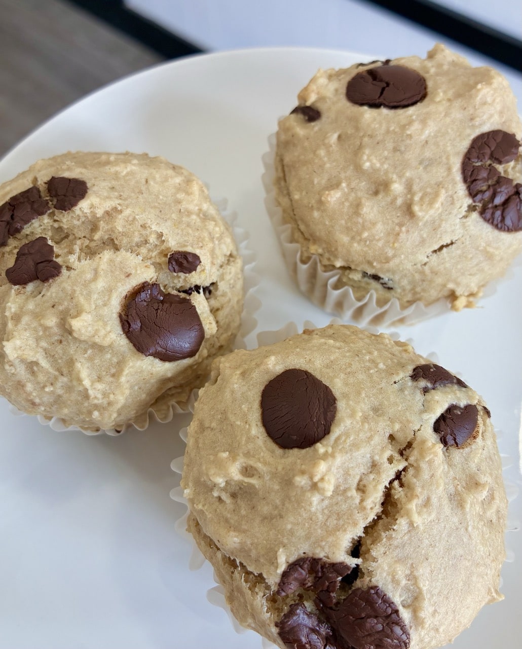 Fluffy healthy oat flour chocolate chip muffins served on a clean white plate