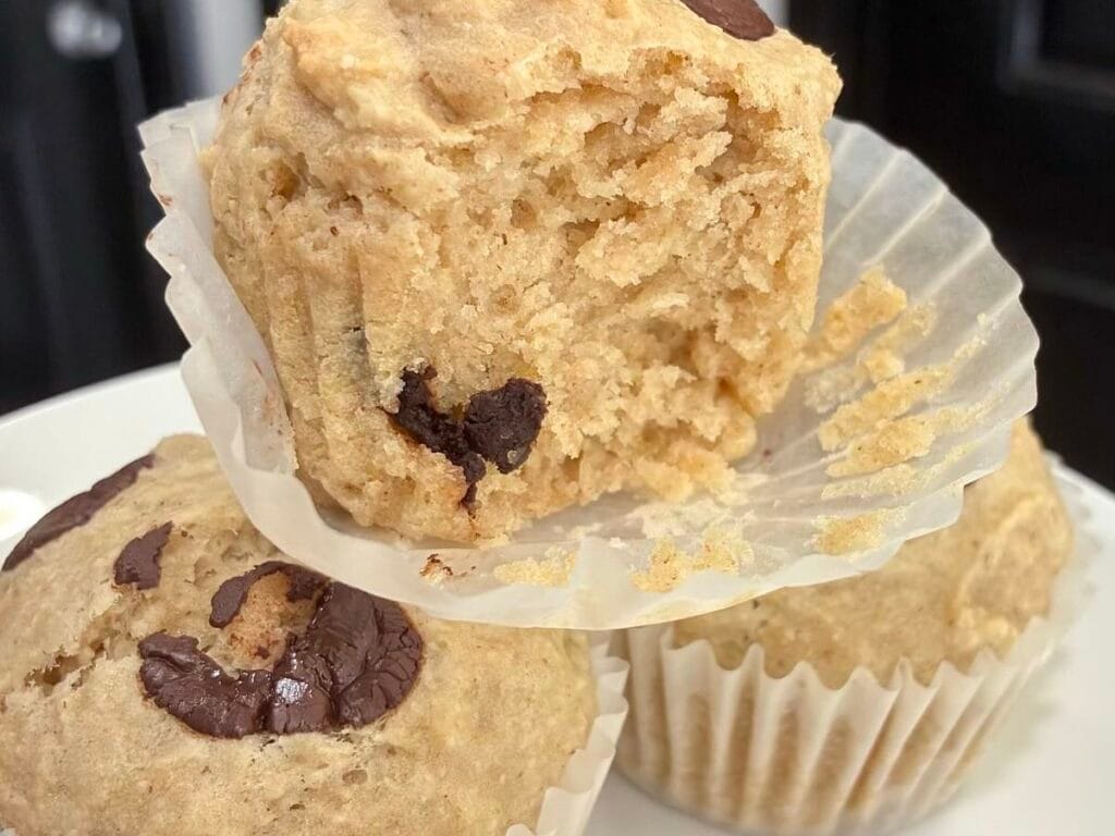 freshly baked oat flour chocolate chip muffins on a white plate