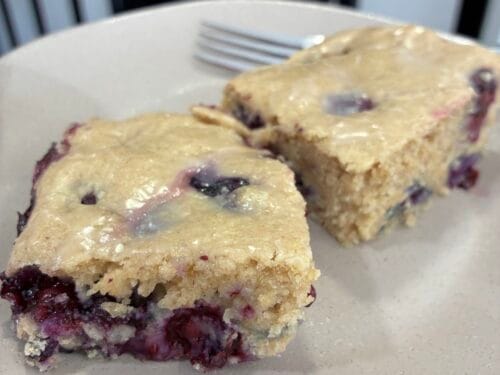 Slice of moist eggless blueberry oat flour cake on a plate