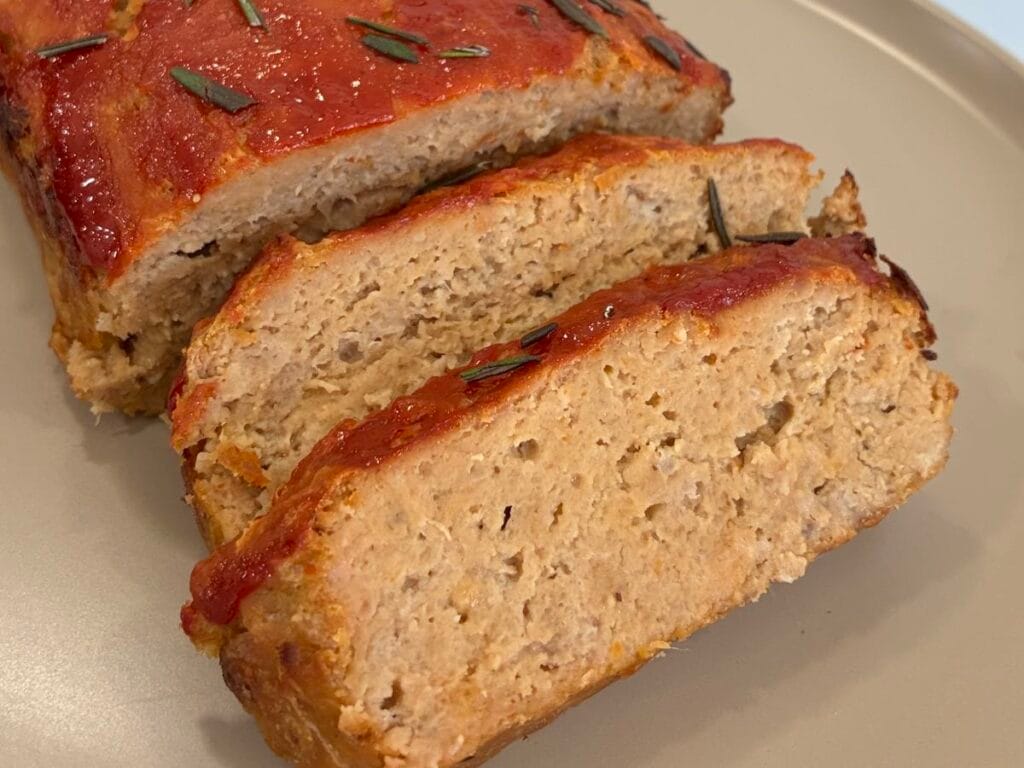 Close up of a juicy sliced traditional glazed turkey meatloaf showing a tender interior crumb
