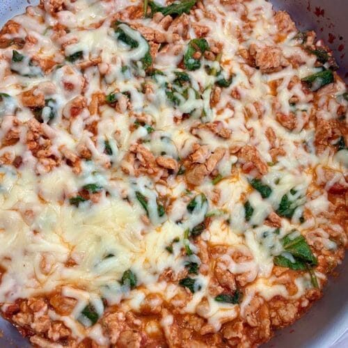 Creamy tomato garlic ground turkey skillet melt with melted cheese bubbling inside a large skillet pan.