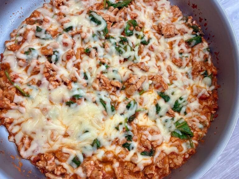 Creamy tomato garlic ground turkey skillet melt with melted cheese bubbling inside a large skillet pan.