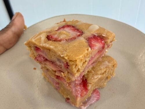 A slice of strawberry applesauce snack cake stacked to show the soft, jammy texture.