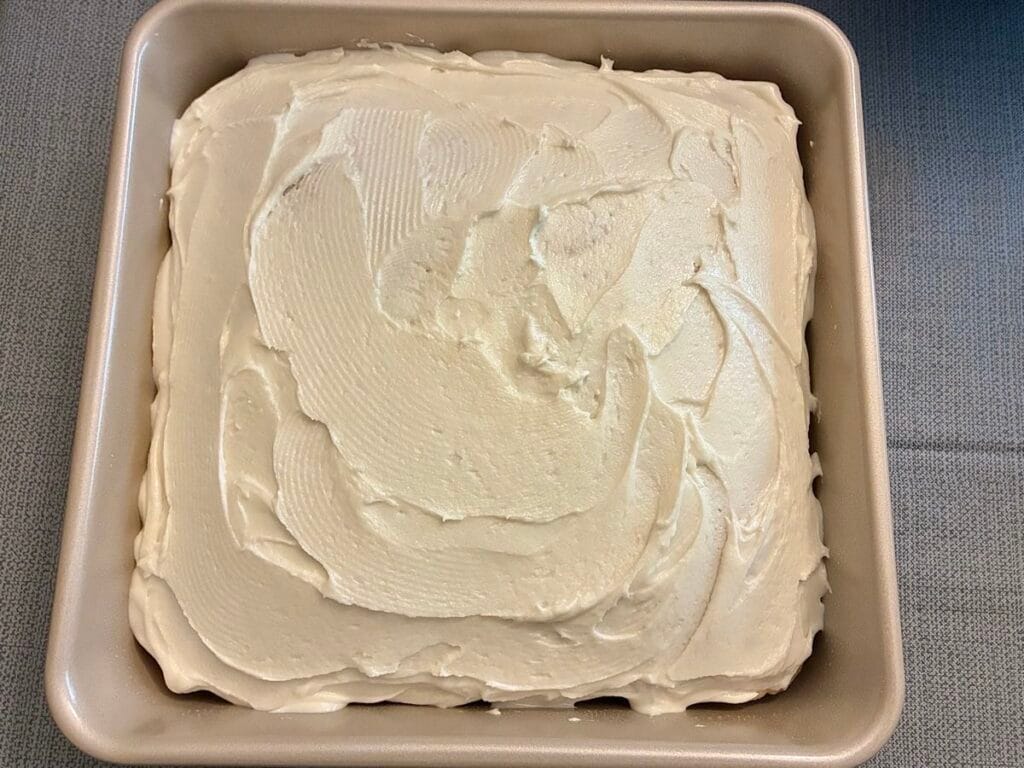 Easy One-Bowl Eggless Vanilla Almond Cake (8x8 Snack Cake) 4 An 8x8 inch square vanilla almond snack cake topped with a smooth, creamy layer of homemade white frosting at Savor Your Bite blog.