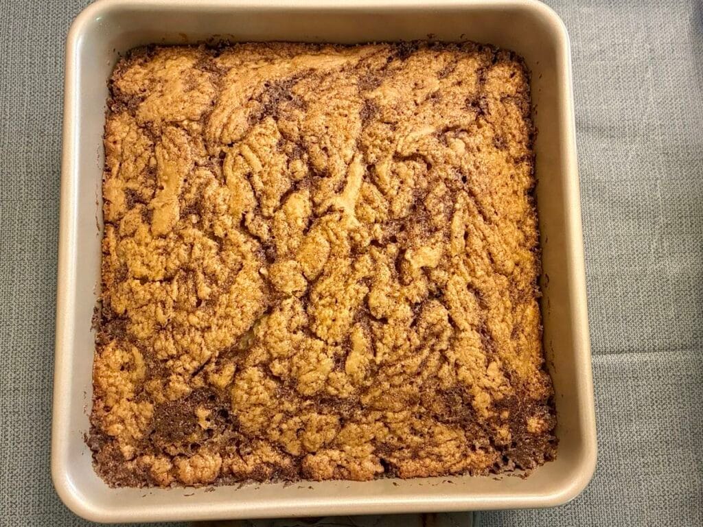 One-Bowl Cinnamon Swirl Snack Cake (Egg-Free Recipe) 3 A freshly baked egg-free cinnamon swirl snack cake cooling inside an 8x8 square baking pan before adding glaze.