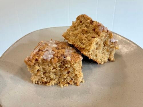 A beautiful presentation of square slices of soft one-bowl cinnamon swirl snack cake on a plate, highlighting the brown sugar swirls.