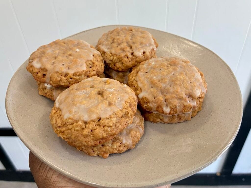 A beautiful presentation plate showing four separate stacks of two chewy iced oatmeal cookies each, highlighting the perfect icing layers.