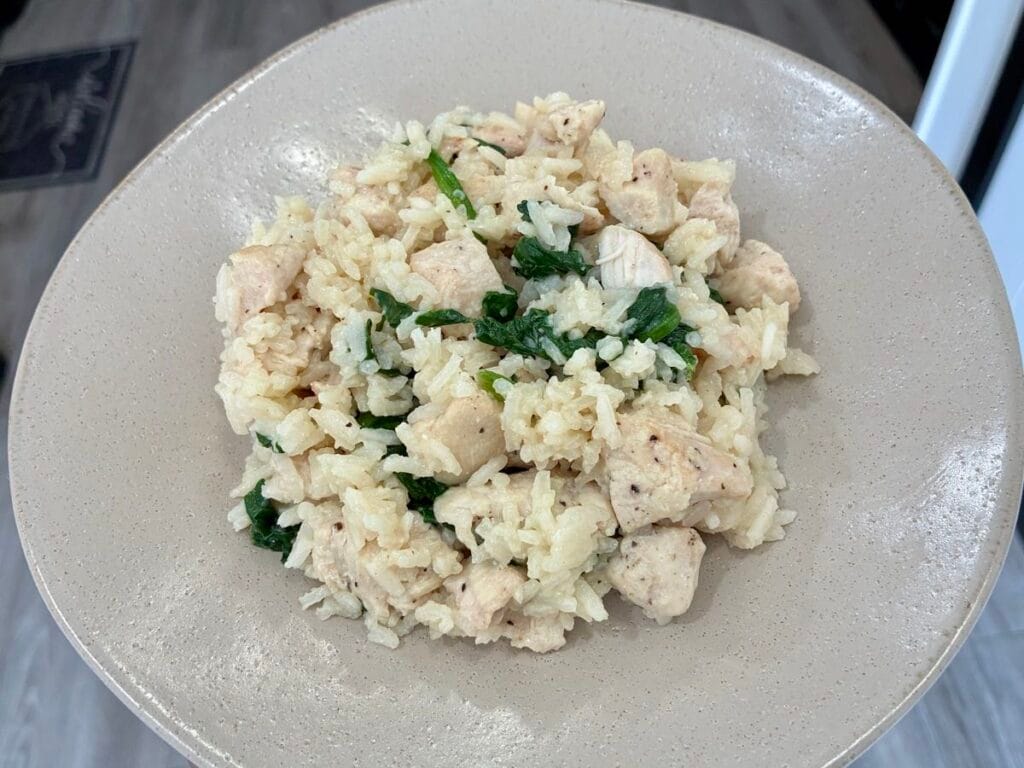 A comforting plate filled with a warm serving of 20-minute one pan creamy garlic chicken and rice.