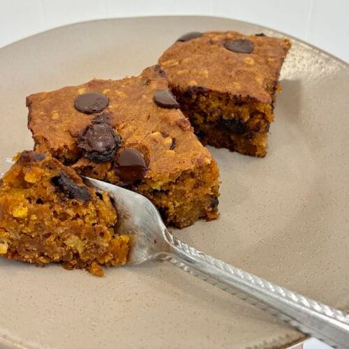Healthy Eggless Pumpkin Chocolate Chip Snack Cake (8x8 Pan) 6 A close-up shot of a fork slicing into a thick, tender piece of the wholesome eggless pumpkin chocolate chip snack cake made with a twist of quick oats.